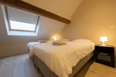 a bedroom with two beds and a window at B&B 't Maanhof in Gingelom