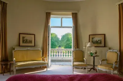 a bedroom with two chairs and a large window at Kasteel Duras in Sint-Truiden
