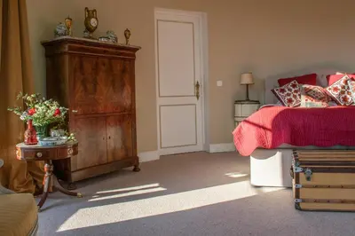 a bedroom with a bed and a dresser next to a bed at Kasteel Duras in Sint-Truiden