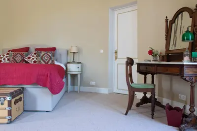a bedroom with a bed and a table and a desk at Kasteel Duras in Sint-Truiden