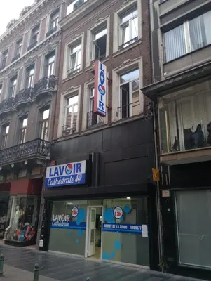 a building with a sign for a store on a street at Studio donceel in Liège