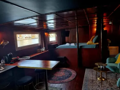 a room with a table and a bed on a train at La Cabine du Capitaine in Liège