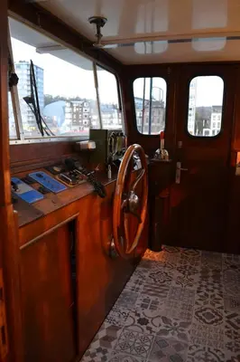 a wooden boat with a counter in a room at La Cabine du Capitaine in Liège