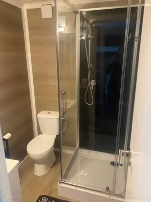 a bathroom with a toilet and a glass shower at Nieuw vebouwd Vakantie Boshuisje Meibloempje in Lanaken