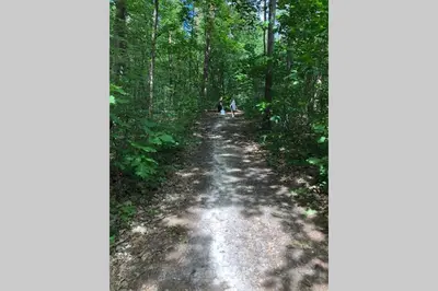 two people walking down a dirt road in the woods at Nieuw vebouwd Vakantie Boshuisje Meibloempje in Lanaken