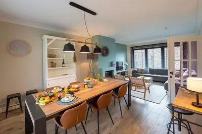a kitchen and living room with a table and chairs at Huize Idalie in Bilzen