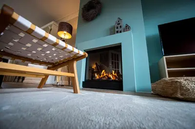 a living room with a fireplace and a tv at Huize Idalie in Bilzen