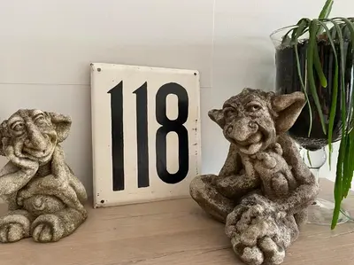 two statues of dogs sitting next to a clock at Den 118, aan de Maas in Maasmechelen