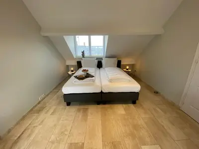 a bedroom with a bed in an attic at Den 118, aan de Maas in Maasmechelen