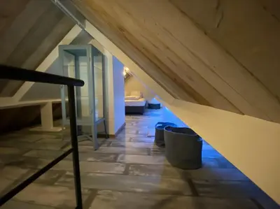 a attic room with a staircase and two trash cans at Den 118, aan de Maas in Maasmechelen