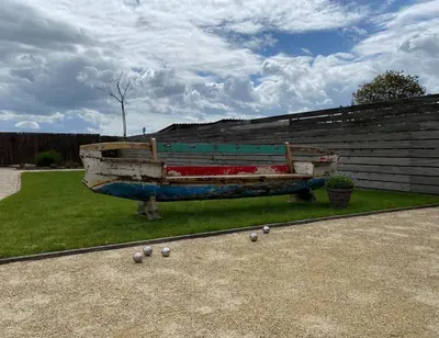 a boat sitting on the grass with balls on the ground at Den 118, aan de Maas in Maasmechelen