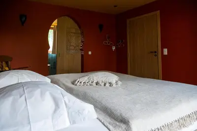 a bedroom with red walls and a white bed at Un air de bourlingueurs in Pepinster