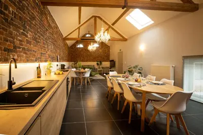 a kitchen and dining room with tables and chairs at B&B Haspenhoeve in Tongeren