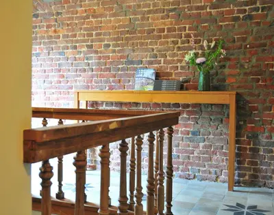 a brick wall with a wooden railing and a brick staircase at B&B Haspenhoeve in Tongeren