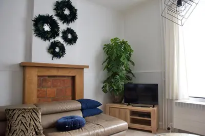 a living room with a couch and wreaths on the wall at Vakantiewoning Oudsbergen in Oudsbergen