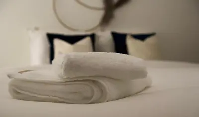 a stack of white towels sitting on a bed at Vakantiewoning Oudsbergen in Oudsbergen