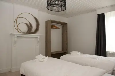a white room with two beds and a mirror at Vakantiewoning Oudsbergen in Oudsbergen