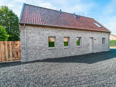 a brick house with a red roof on a gravel driveway at Bocholt Family Home, Bocholt in Bocholt