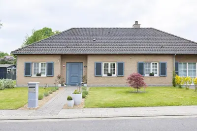 a house with a blue door and a yard at B&b La Villa Orchidées, breakfast included in Bassenge