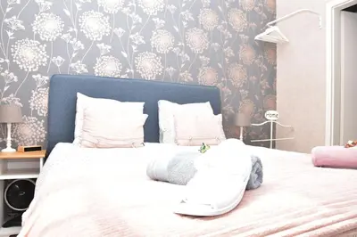 a bedroom with a large white bed with a blue headboard at B&b La Villa Orchidées, breakfast included in Bassenge