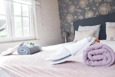 a bedroom with a white bed with towels on it at B&b La Villa Orchidées, breakfast included in Bassenge