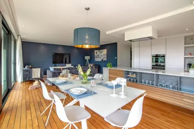 a kitchen and dining room with a white table and chairs at Au bois du Sart-Tilman in Sur le Mont