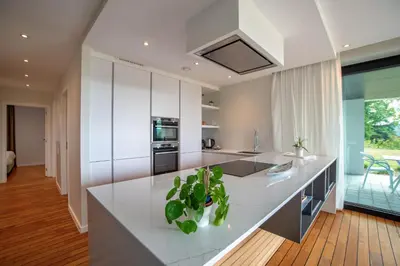 a kitchen with white cabinets and a counter with plants at Au bois du Sart-Tilman in Sur le Mont