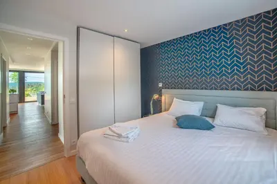 a bedroom with a large white bed with a blue wall at Au bois du Sart-Tilman in Sur le Mont