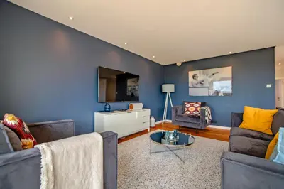 a living room with two couches and a tv at Au bois du Sart-Tilman in Sur le Mont