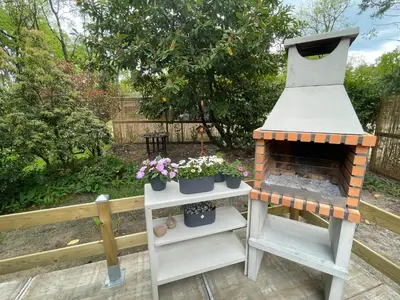 a garden with a stove and some plants on shelves at Chalet Harmony in Zutendaal