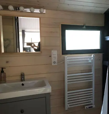 a bathroom with a sink and a tv on the wall at Chalet Harmony in Zutendaal