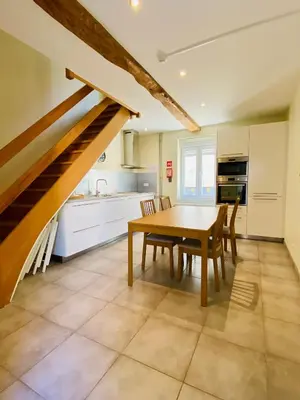 a kitchen with a table and chairs and a staircase at Les gîtes du Broukay - Alouette in Bassenge