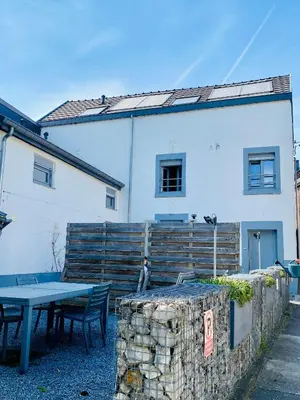 a table and chairs in front of a white building at Les gîtes du Broukay - Hirondelle in Bassenge