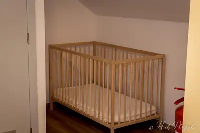 a crib in the corner of a room at Les gîtes du Broukay - Hirondelle in Bassenge