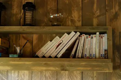a row of books sitting on a book shelf at Le Relais d'Artagnan - relais équestre in Mortier