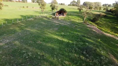a small cabin on a hill with a green field at Le Relais d'Artagnan - relais équestre in Mortier