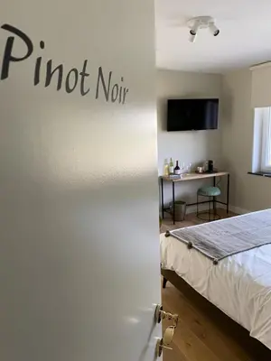a door to a room with a bed and a desk at B&B Gellick in Lanaken