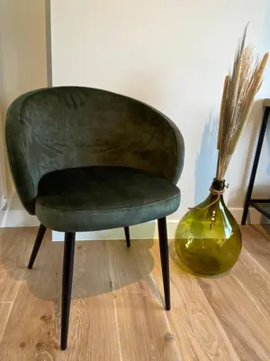 a green chair sitting next to a vase at B&B Gellick in Lanaken