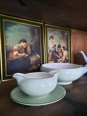 two white bowls sitting on plates in front of paintings at B&B Gellick in Lanaken