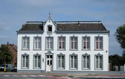 a large white building with a gambrel roof at B&B Het Doctershoes in Kinrooi