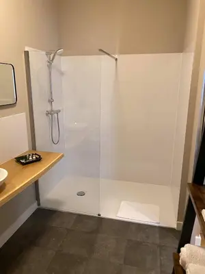 a shower with a glass door in a bathroom at B&B Het Doctershoes in Kinrooi