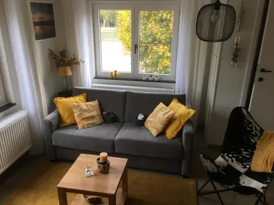 a living room with a couch and a window at Villa van Brienen - Studio in Dilsen-Stokkem