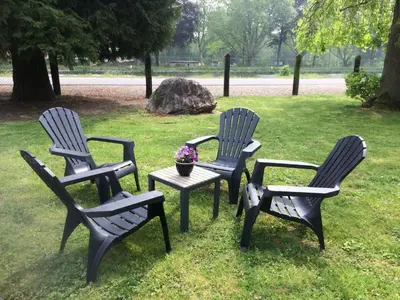 three chairs and a table with a flower pot in a park at Villa van Brienen - Studio in Dilsen-Stokkem