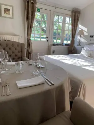 a table with wine glasses on it next to a bed at de Bosch in Lummen