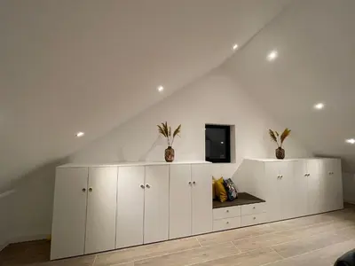 a room with white cabinets and a tv on a ceiling at Luna Logies in Lanaken