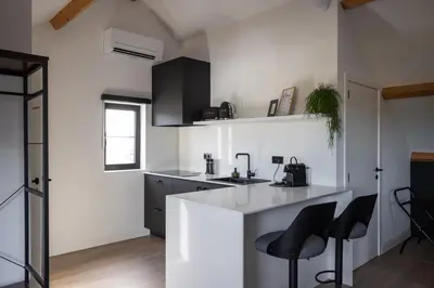a kitchen with a white counter and black cabinets at Luna Logies in Lanaken