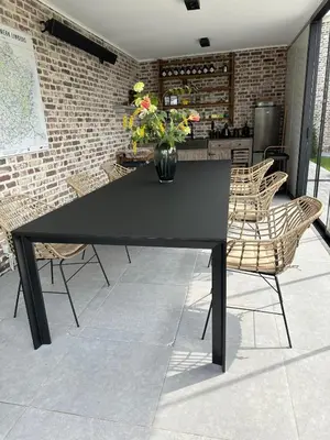 a black table with chairs and a vase of flowers at Luna Logies in Lanaken