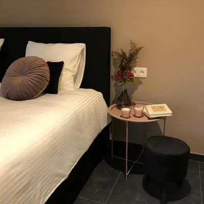 a hotel room with a bed and a table with a phone at Huis Berenbroek in Genk