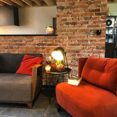 a living room with a couch and a table with a lamp at Huis Berenbroek in Genk