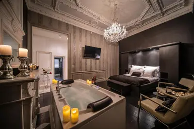 a bathroom with a bath tub and a bed at Maison Noppius - Love Hotel in Liège